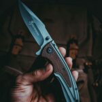 головна A detailed close-up view of a hand holding a sharp tactical knife, depicting precision and craftsmanship.
